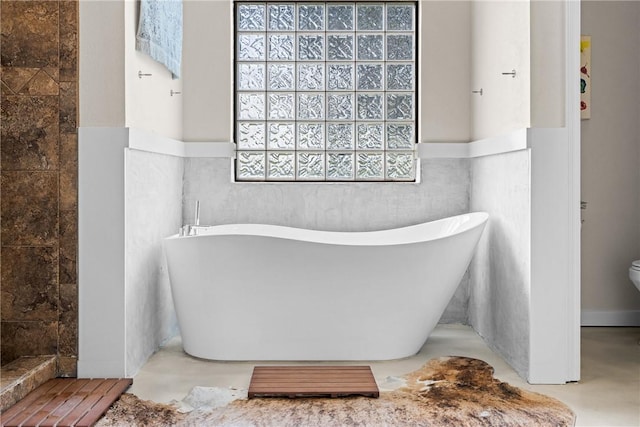 9560 County Road 121, Iola, TX 77861 - full bathroom with wainscoting, a freestanding tub, toilet, and a tile shower