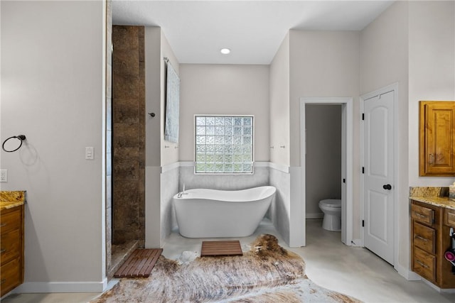 9560 County Road 121, Iola, TX 77861 - full bath with vanity, toilet, a freestanding tub, finished concrete floors, and a wainscoted wall