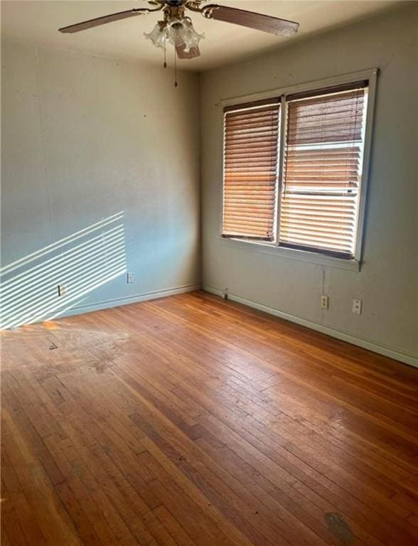 empty room with hardwood / wood-style floors and ceiling fan