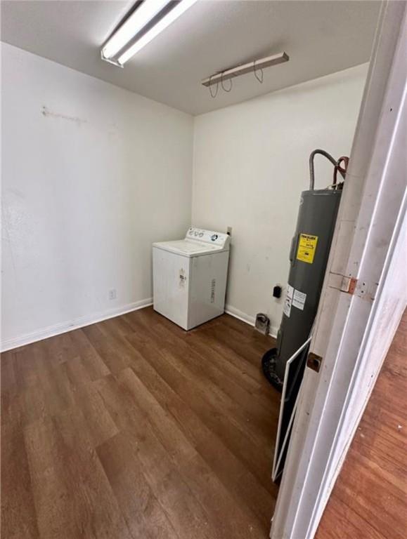 laundry room with dark hardwood / wood-style flooring, washer / dryer, and electric water heater