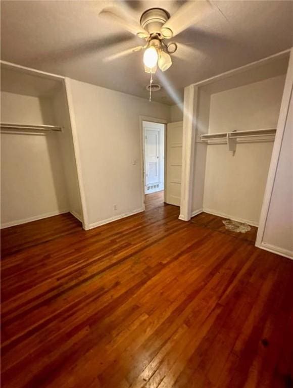 unfurnished bedroom featuring ceiling fan and dark wood-type flooring