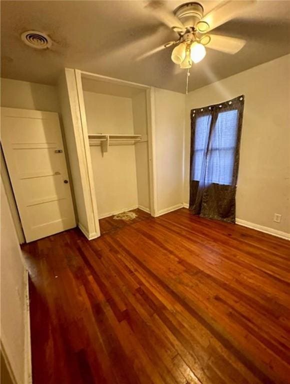 unfurnished bedroom with ceiling fan, a closet, and hardwood / wood-style flooring