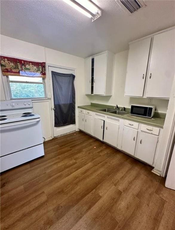 kitchen with white cabinets, white electric range, sink, dark hardwood / wood-style floors, and a textured ceiling