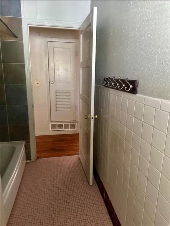 bathroom featuring tile walls and hardwood / wood-style flooring