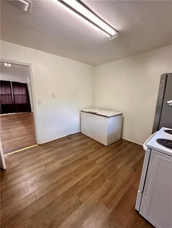 laundry room with dark hardwood / wood-style flooring and a textured ceiling