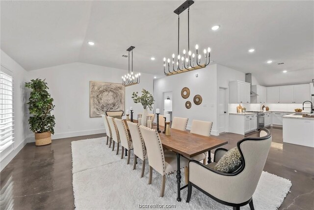 dining area with a chandelier, lofted ceiling, and sink