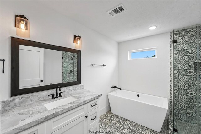 bathroom with tile patterned floors, vanity, and plus walk in shower