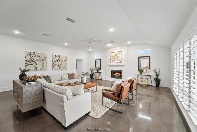 living room featuring ceiling fan, a large fireplace, and lofted ceiling