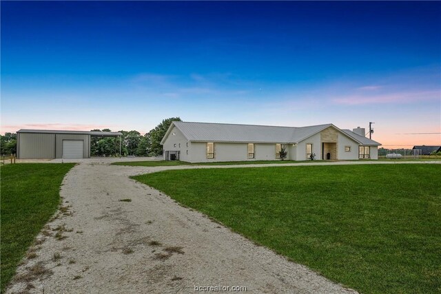 view of front of property featuring an outbuilding, a garage, and a lawn