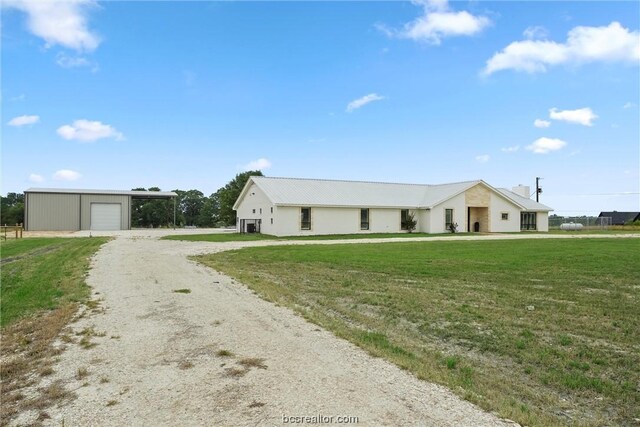 view of front facade featuring a front yard, an outdoor structure, and a garage