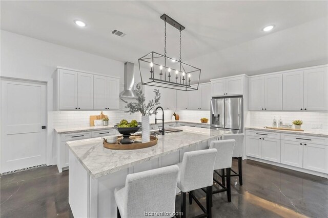 kitchen featuring decorative backsplash, white cabinetry, and hanging light fixtures