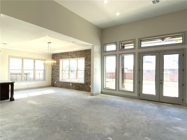 unfurnished room featuring brick wall, french doors, unfinished concrete flooring, and visible vents