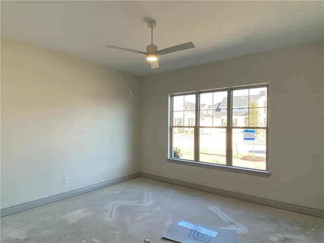 empty room featuring ceiling fan, unfinished concrete flooring, and baseboards