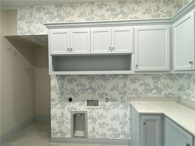 laundry area featuring wallpapered walls, electric dryer hookup, and cabinet space