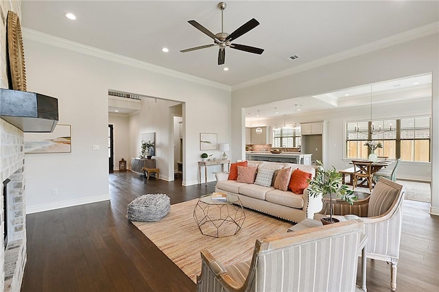 living room featuring dark hardwood / wood-style floors, ceiling fan, and crown molding