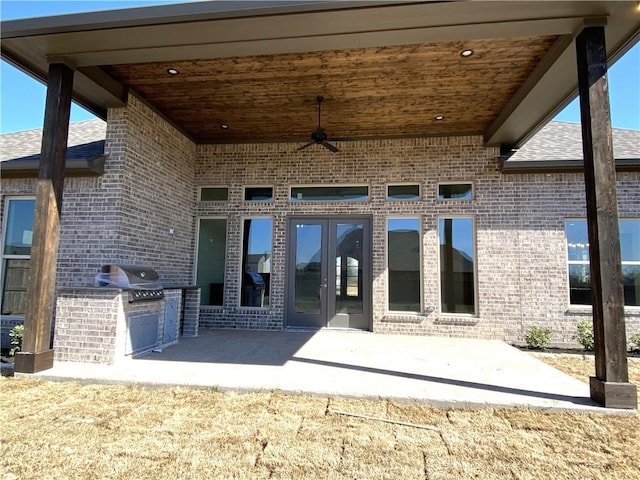 exterior space featuring a patio, brick siding, an outdoor kitchen, and a ceiling fan