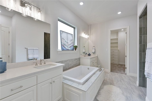 bathroom with vanity and tiled bath