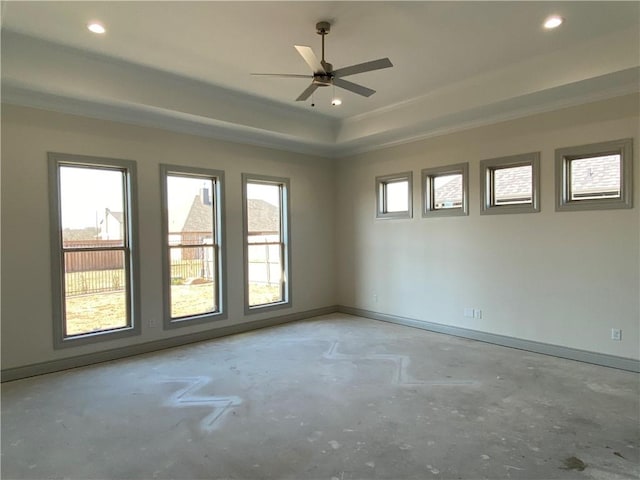 empty room with a tray ceiling, recessed lighting, unfinished concrete flooring, and baseboards