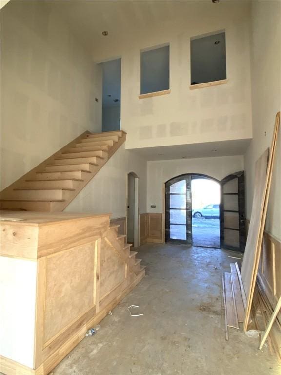 interior space featuring concrete flooring and a towering ceiling