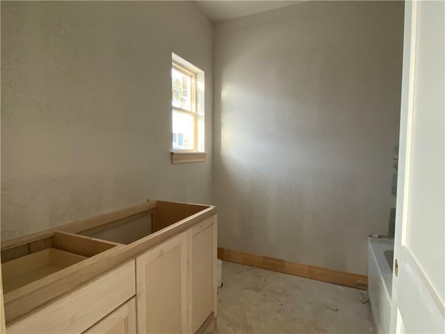 bathroom featuring a bathing tub, vanity, and concrete floors