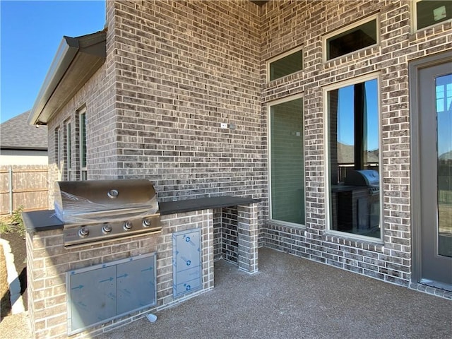 view of patio featuring area for grilling and fence