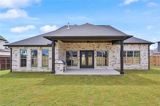 rear view of property with french doors, a yard, ceiling fan, and a patio area