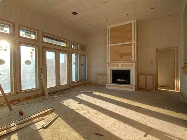 unfurnished living room featuring french doors and a high ceiling