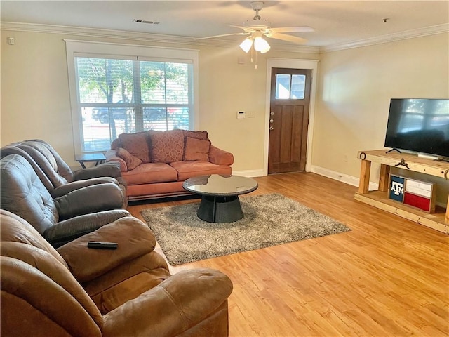 living room with crown molding, plenty of natural light, and wood-type flooring