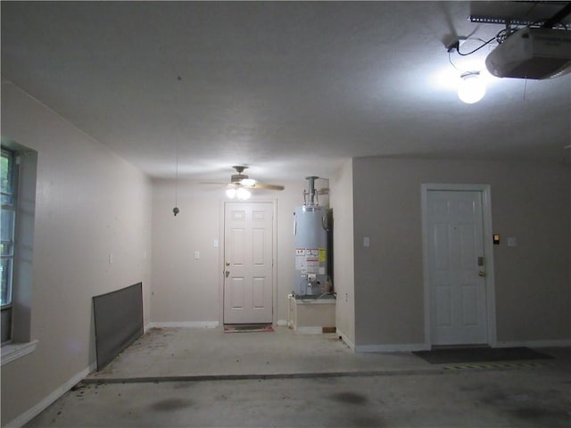 2400 Brookbend Dr, Brenham, TX 77833 - garage featuring a garage door opener, gas water heater, and ceiling fan