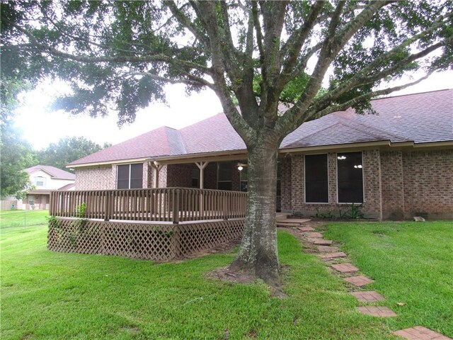 2400 Brookbend Dr, Brenham, TX 77833 - rear view of property featuring brick siding, a lawn, and a wooden deck