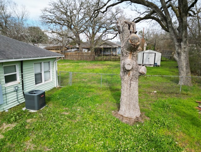 view of yard featuring central AC unit and a storage shed