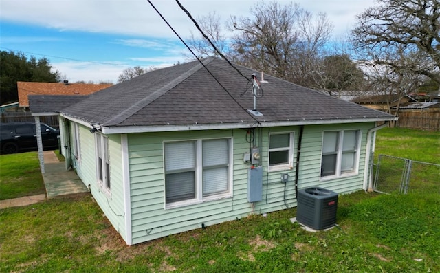 rear view of house with a yard and central AC