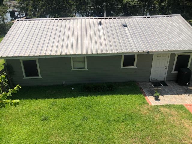 rear view of house with a patio area and a lawn