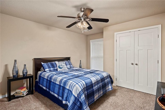 carpeted bedroom with a textured ceiling, a closet, and ceiling fan