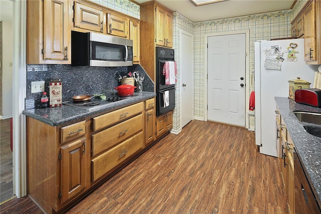 2801 Celinda Cir, College Station, TX 77845 - kitchen featuring stainless steel microwave, electric cooktop, dark countertops, and dark wood-style flooring