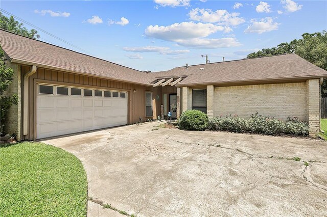 2801 Celinda Cir, College Station, TX 77845 - view of front facade with concrete driveway, an attached garage, a shingled roof, and brick siding