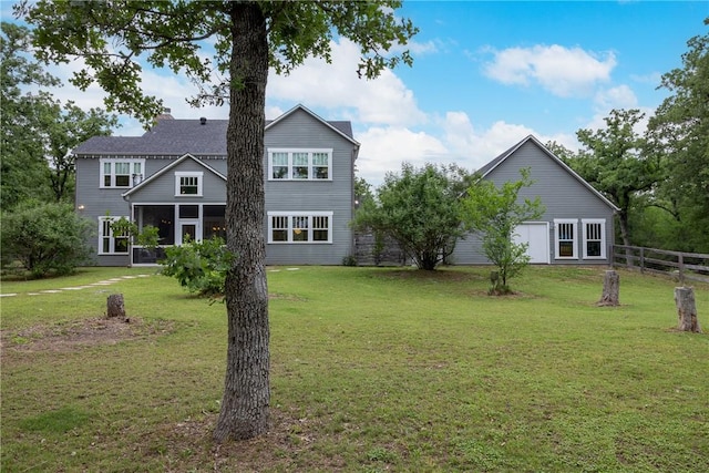 back of house featuring a lawn, fence, a chimney, and a sunroom