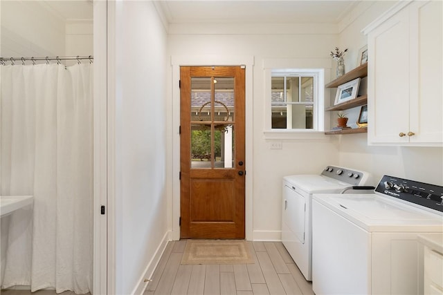 laundry room with crown molding, light wood-type flooring, cabinet space, baseboards, and washer and clothes dryer