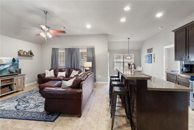 living room with light tile patterned floors, ceiling fan, vaulted ceiling, and recessed lighting