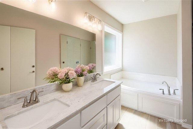 bathroom featuring hardwood / wood-style flooring, a bathtub, and vanity