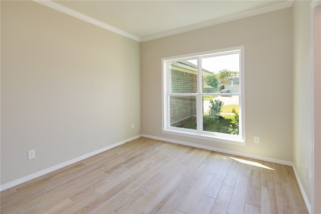 empty room featuring light hardwood / wood-style flooring and ornamental molding