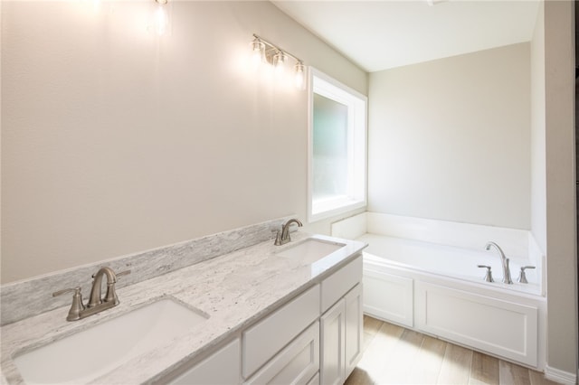 bathroom with a tub to relax in, vanity, and hardwood / wood-style flooring