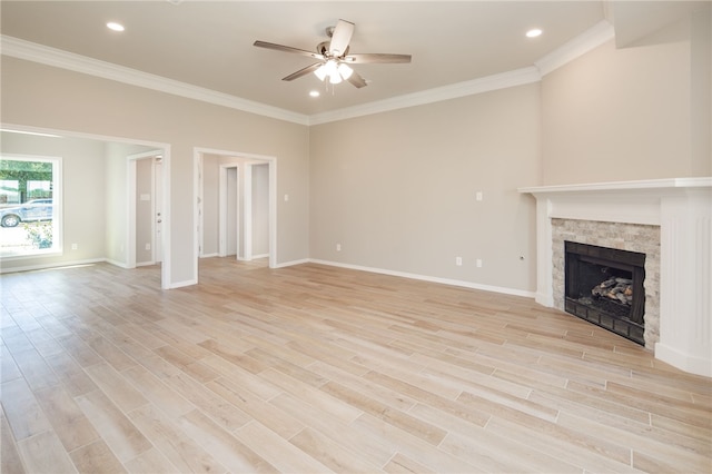 unfurnished living room with crown molding, a fireplace, ceiling fan, and light hardwood / wood-style floors