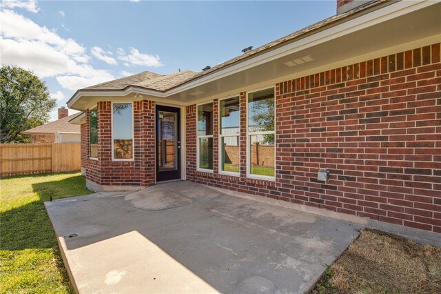 doorway to property with a yard and a patio