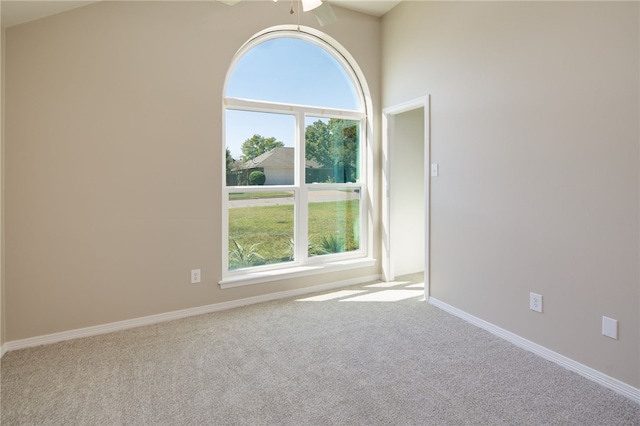 carpeted empty room with ceiling fan and lofted ceiling