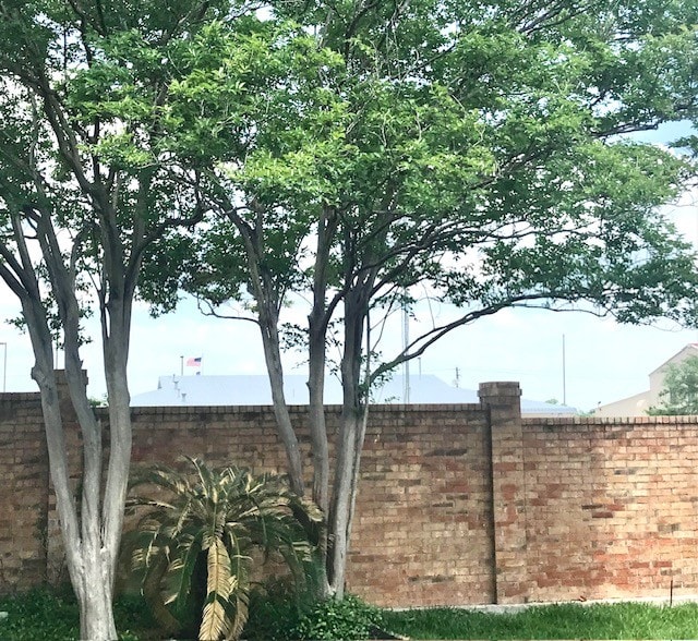 property entrance with fence, a patio area, a chimney, and brick siding