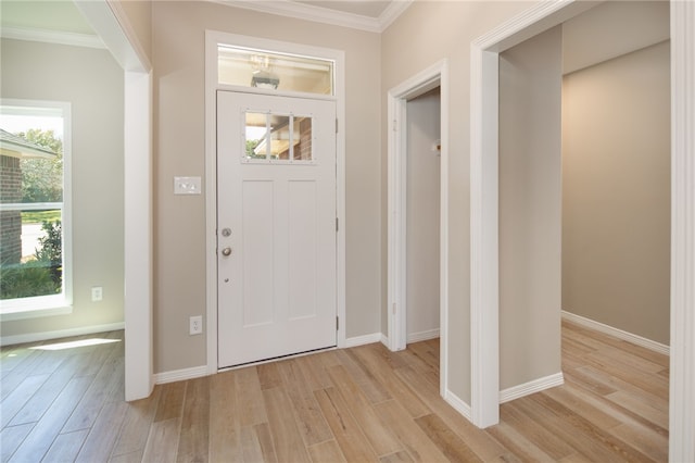 entryway with ornamental molding and light hardwood / wood-style flooring