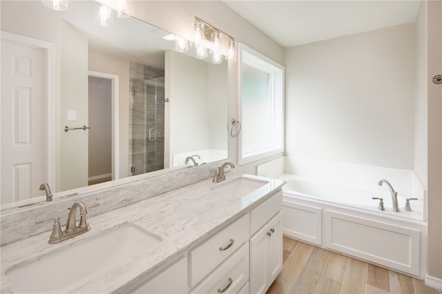 full bathroom featuring a bath, wood finished floors, and a sink