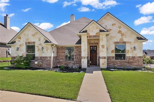 2000 Cassandra Ct, Bryan, TX 77807 - french country style house featuring stone siding, a front yard, and brick siding