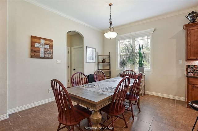 dining area with dark tile patterned floors and ornamental molding